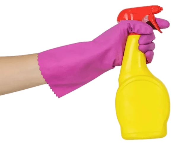 Hand in a pink rubber glove holding a yellow cleaning spray bottle with a red nozzle.